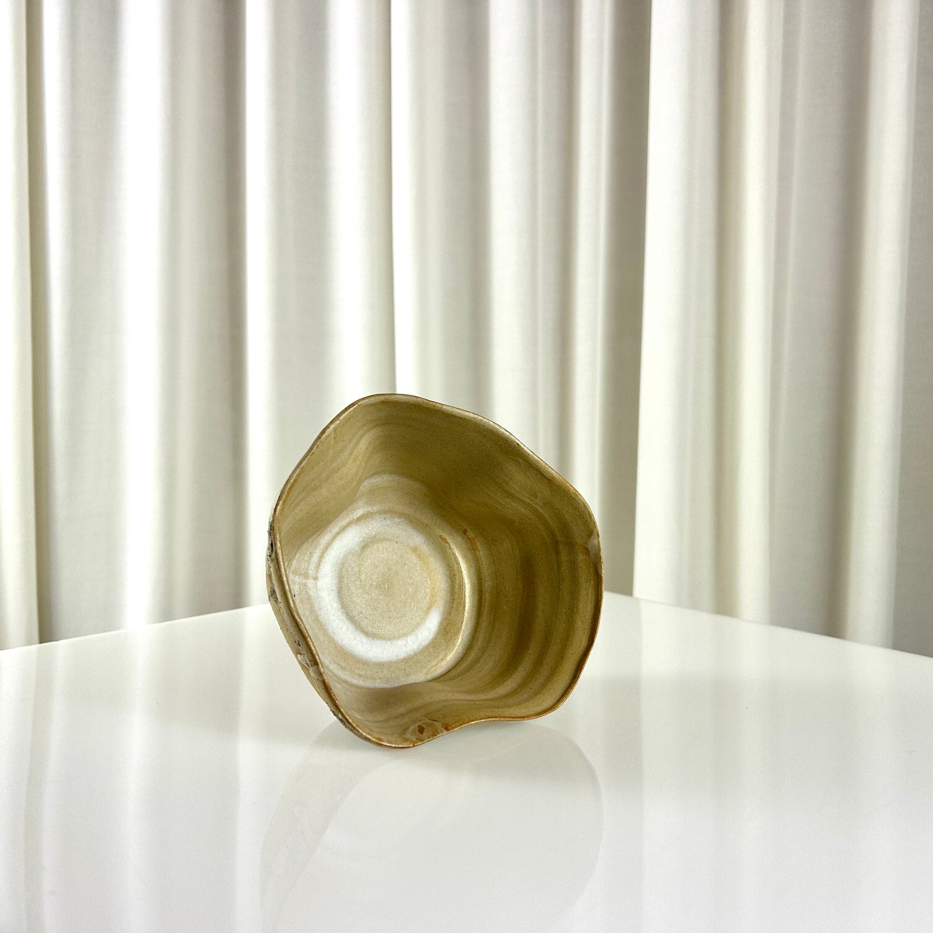 The inner side of a ceramic beige bowl with pattern