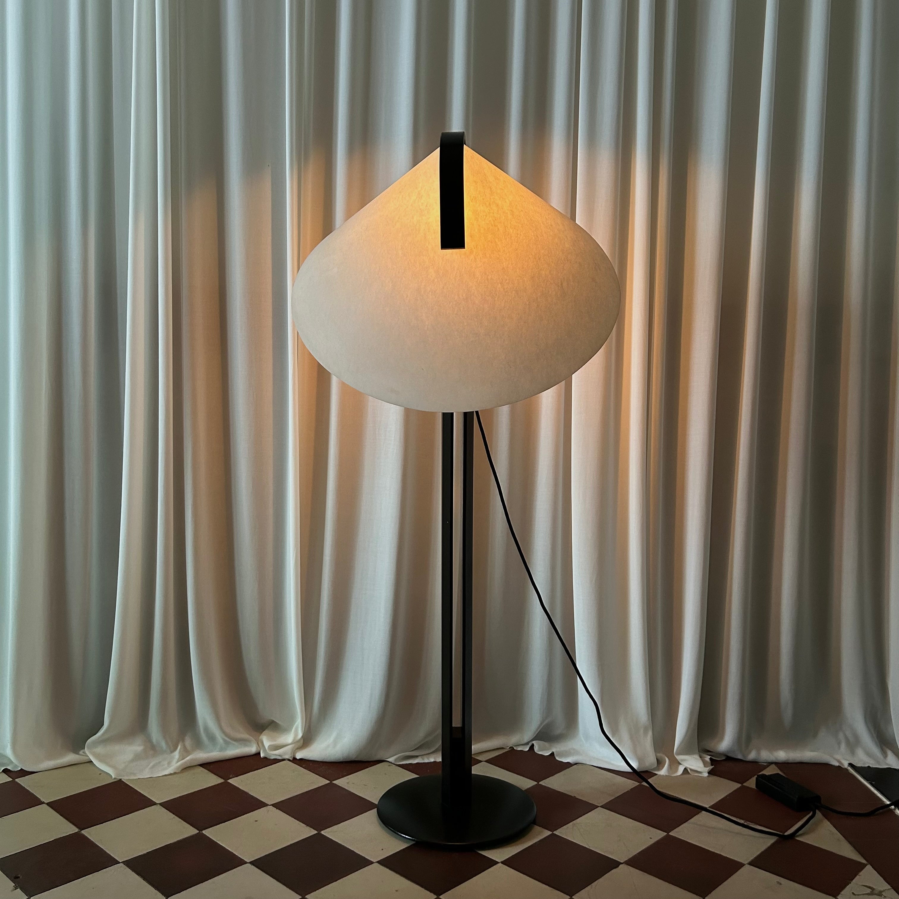 Front image of a lit black and white 1970's floorlamp by the Danish manufacturer Domus