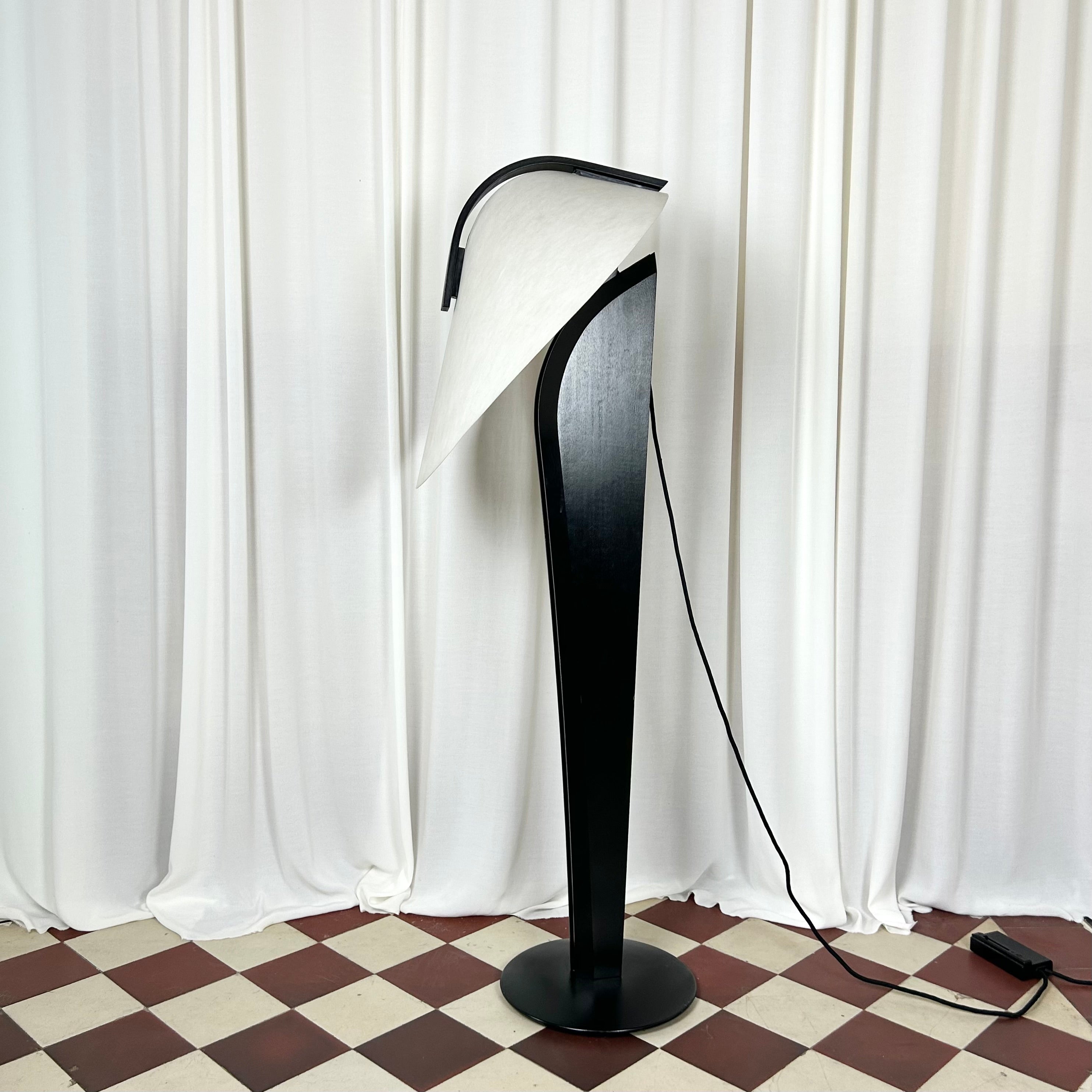 A black and white 1970's floorlamp by the Danish manufacturer Domus, seen in profile with tilted lamp shade