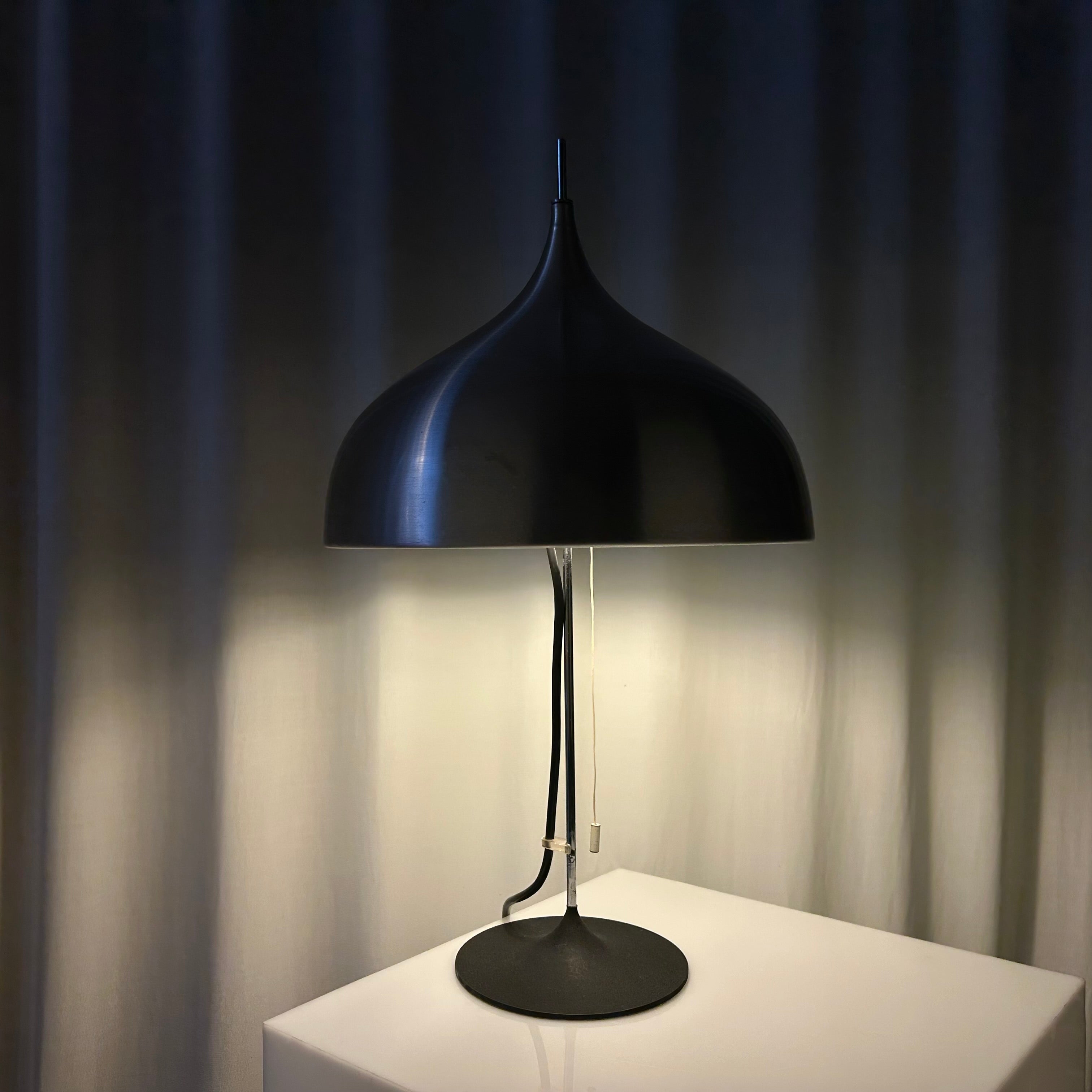 Mid-century modern mushroom shaped table lamp in black and chrome with light on