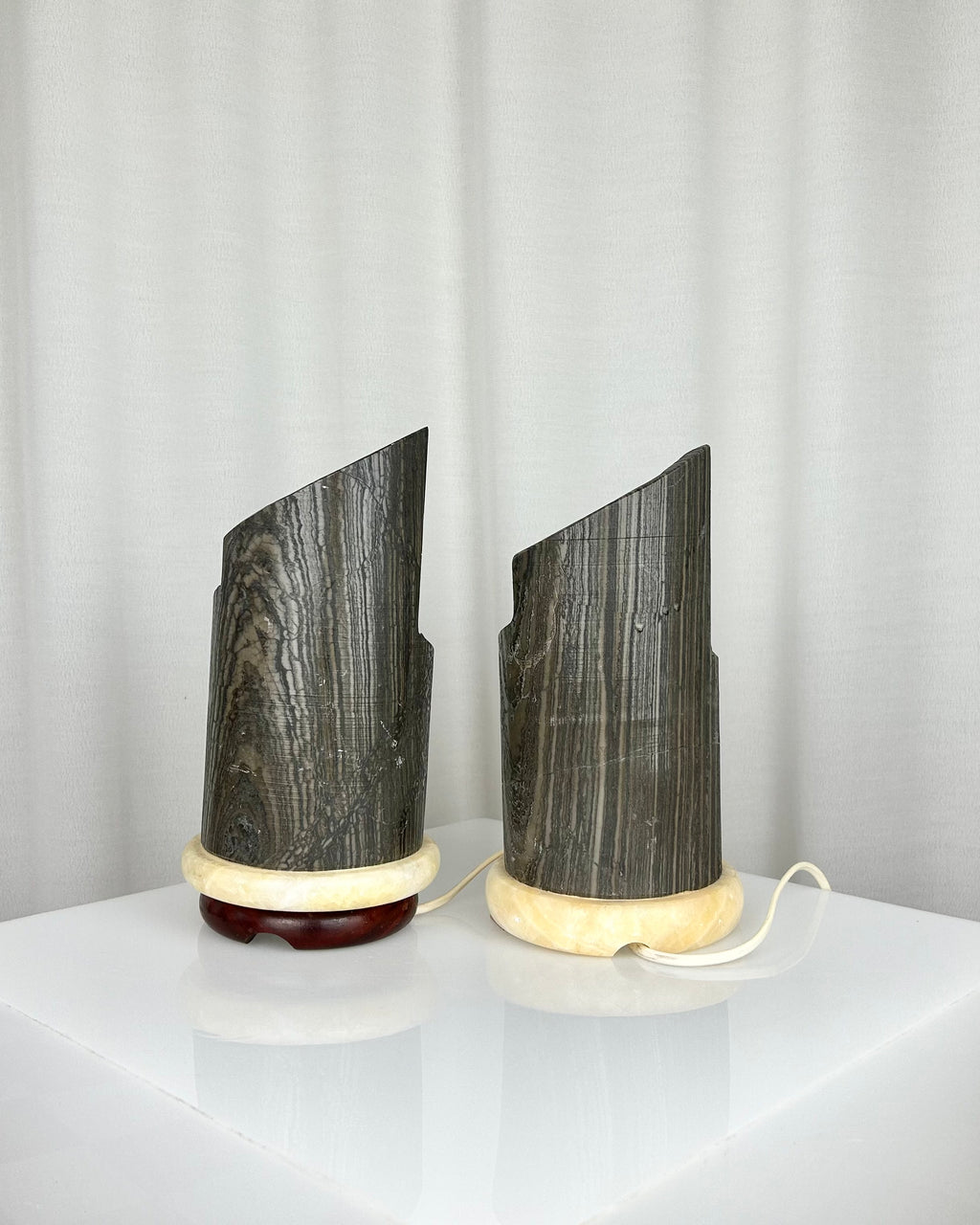 A pair of postmodern table lamps made of solid dark marble with fluted internal alabaster columns.