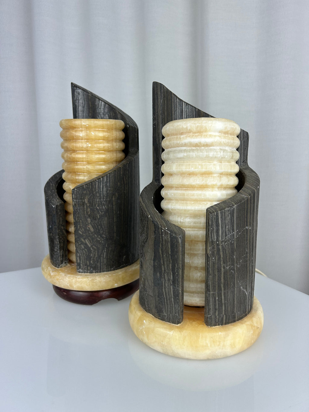 A pair of postmodern table lamps made of solid dark marble with fluted internal alabaster columns.