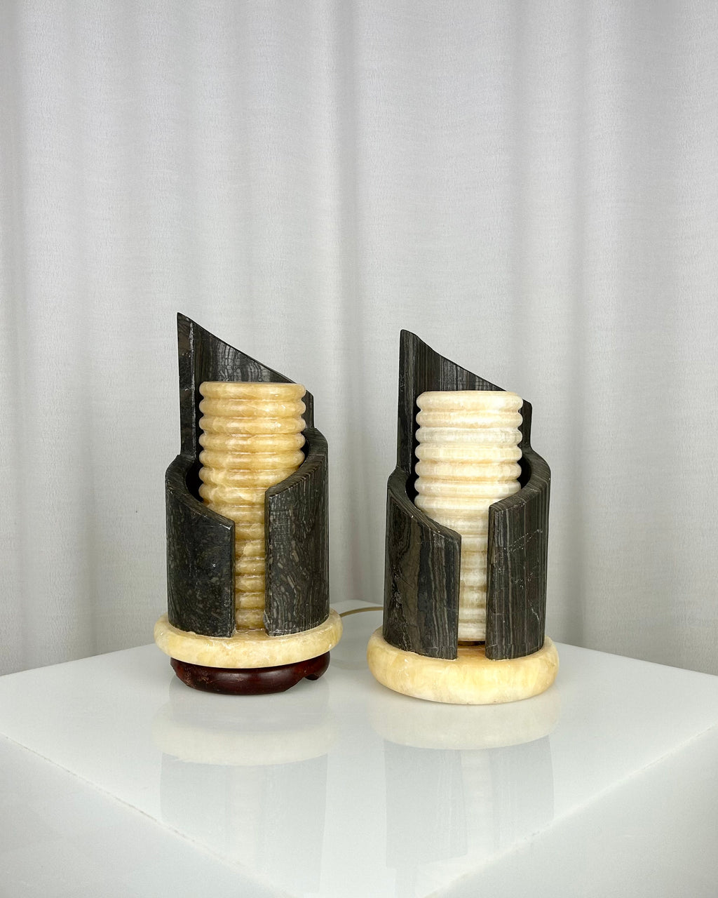 A pair of postmodern table lamps made of solid dark marble with fluted internal alabaster columns.