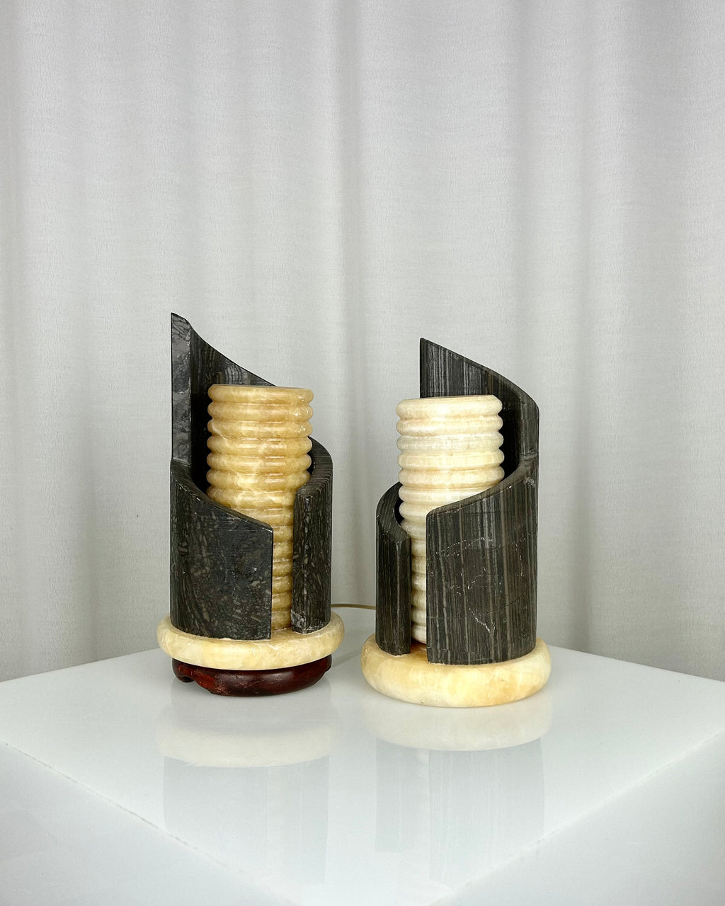 A pair of postmodern table lamps made of solid dark marble with fluted internal alabaster columns.