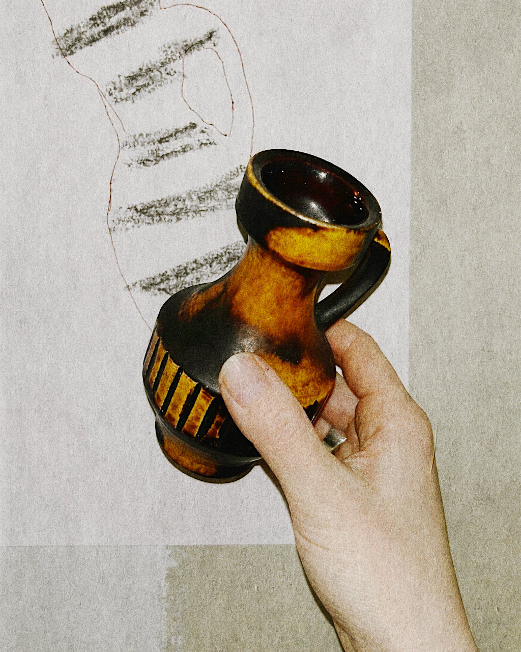 Hand holding a tiny vintage ceramic jug