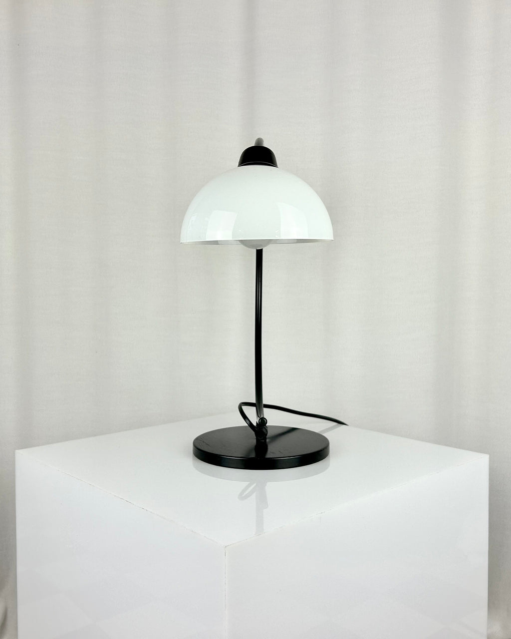 Vintage IKEA Harmoni table lamp featuring a black arched metal frame and a white glass shade, 1980s postmodern design.
