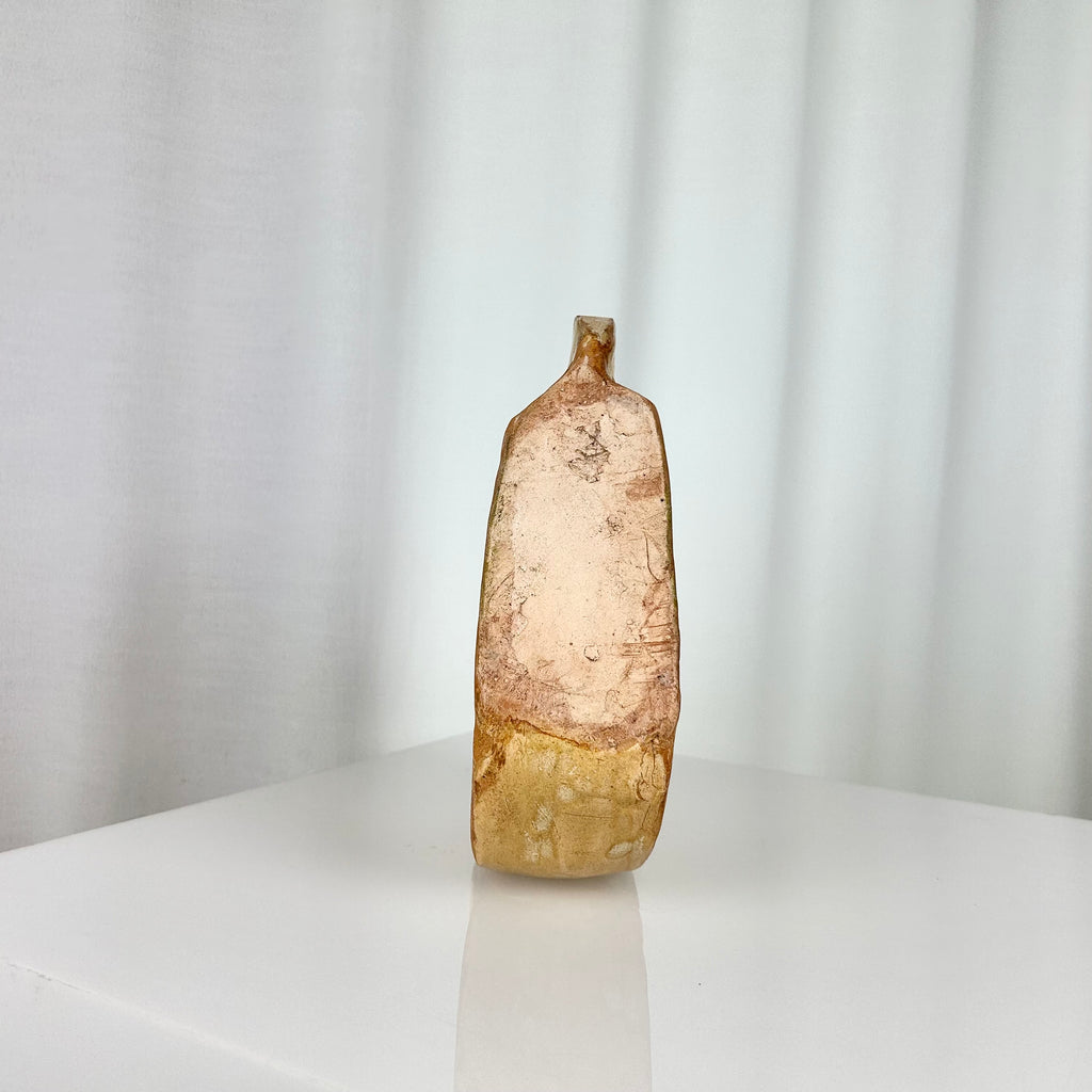 Vintage ceramic vase in sculptural circular form with ochre glaze seen from underneath