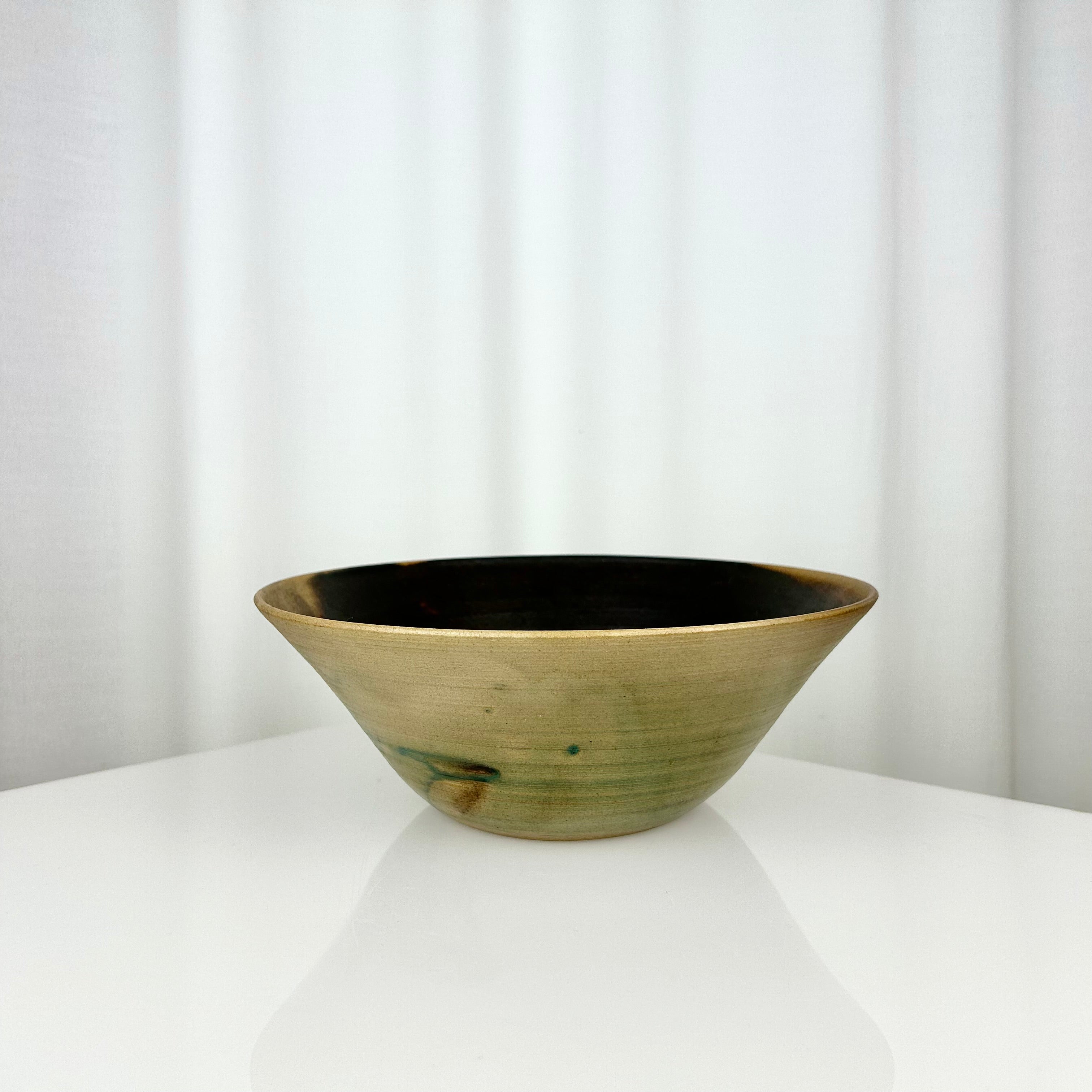 Vintage studio pottery hand-thrown bowl with dark beige and green glaze