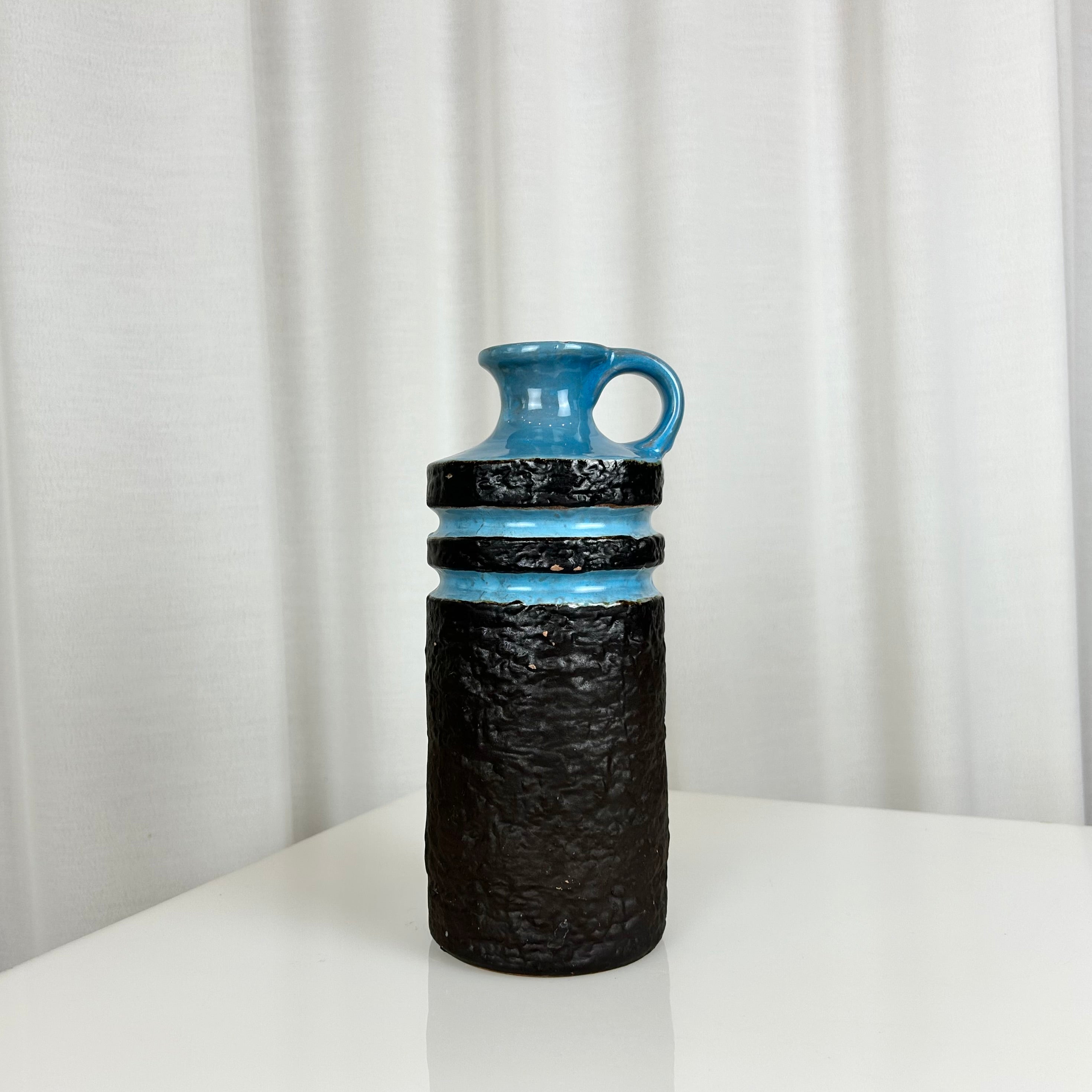 West German fat lava style ceramic vase with textured matte black body and glossy blue rings