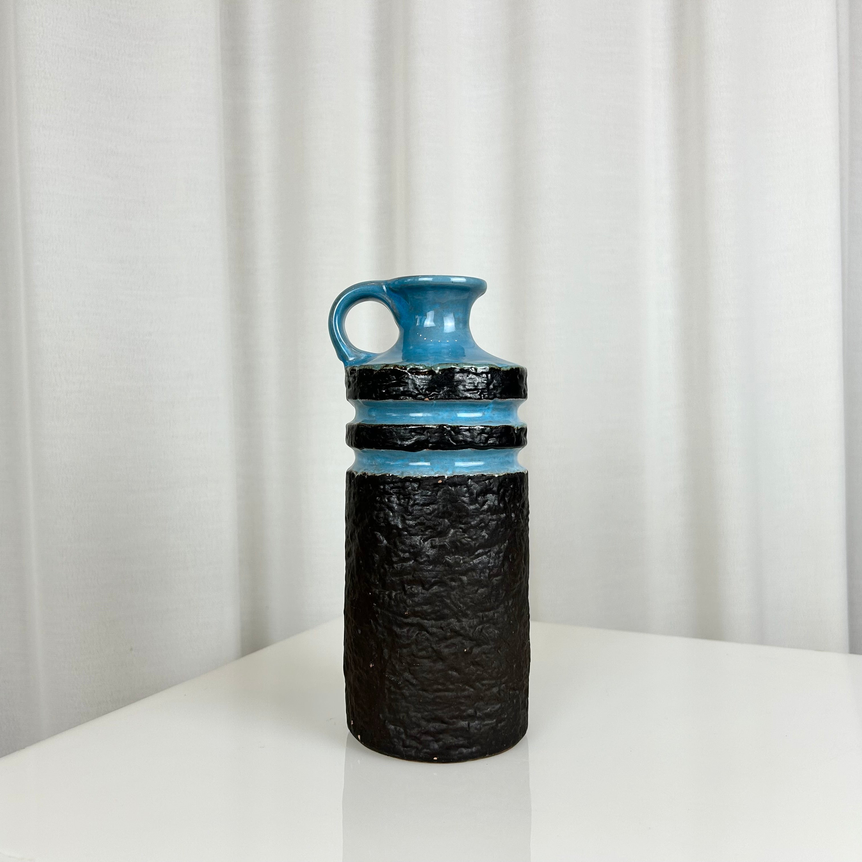 West German fat lava style ceramic vase with textured matte black body and glossy blue rings